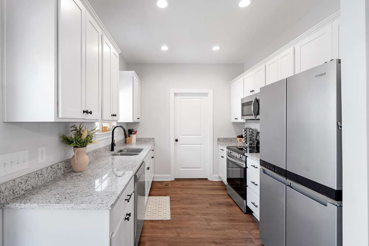 Lovely ktichen featuring granite counter tops, white shaker cabinets, double sink, electric glass cooktop, and SS appliances. (Fridge not to convey).