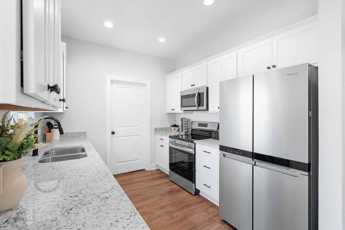 Kitchen has ample lighting with can lights and natural light. Door to the back leads into the Laundry/Utility Room.