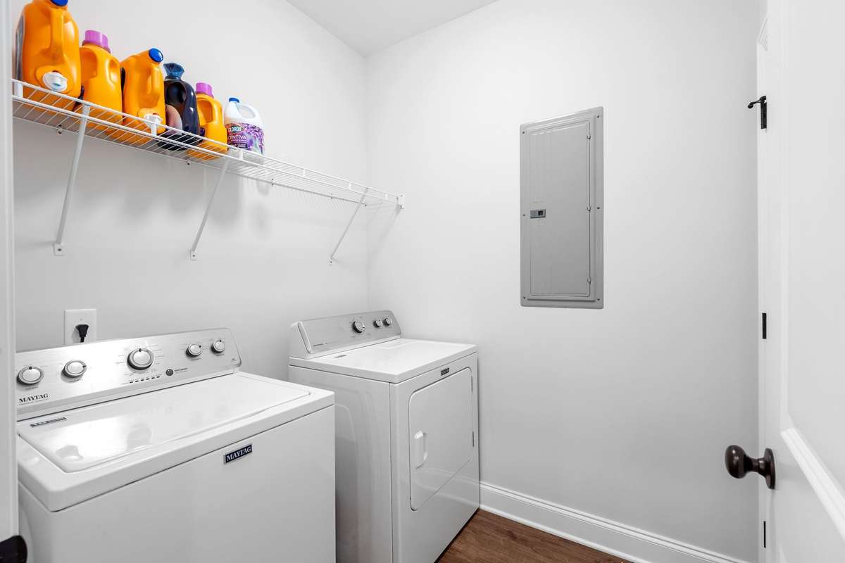 Laundry Room with built in wire shelf + breaker box. Behind the entry door is a double door closet which houses the water heater + plus allows with extra storage.