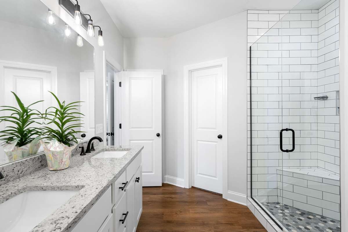 Primary suite bathroom door to the left of the shower is the other walk-in closet.
