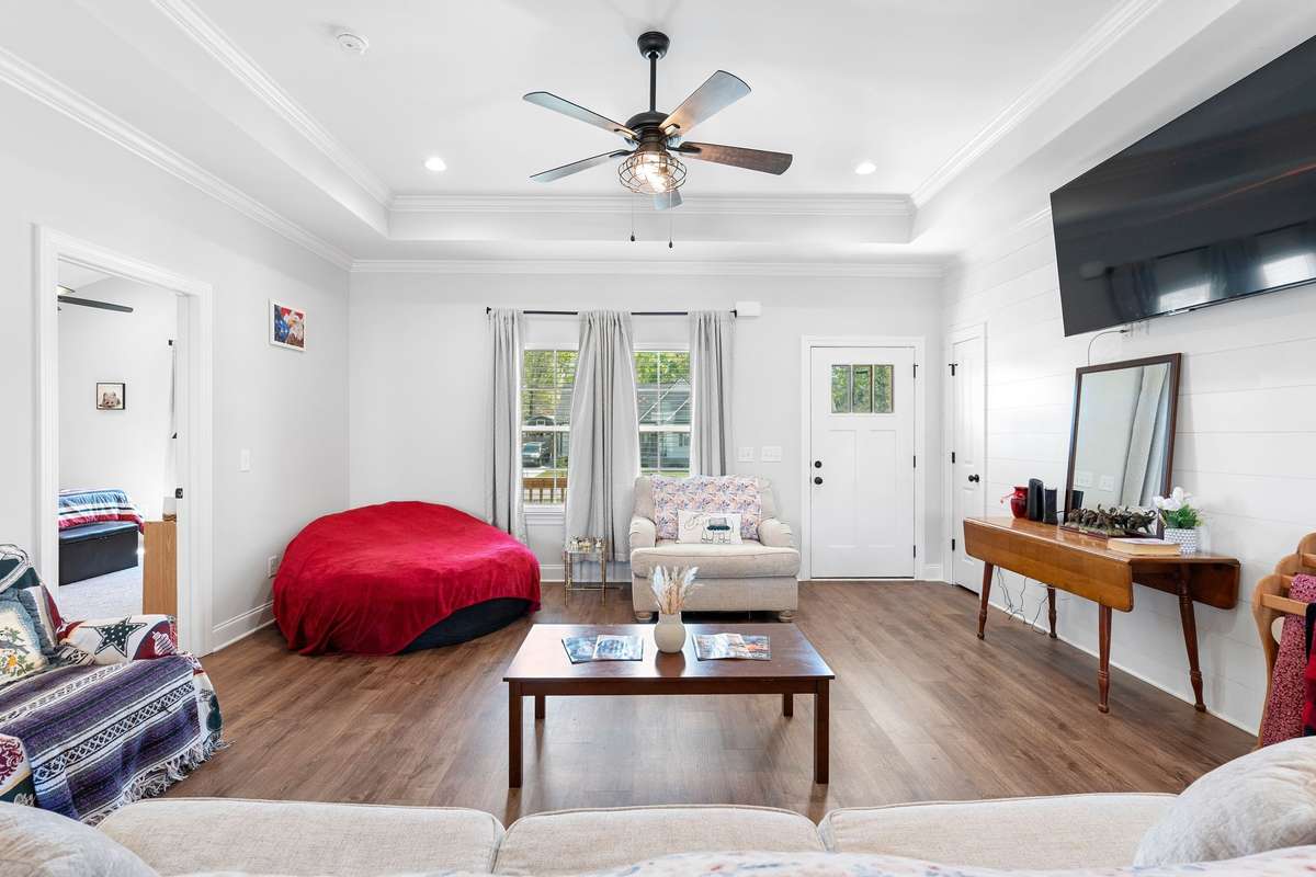 2 tall windows in living room. Door way to the left leads to the Primary suite & door to the right of the entry door is a coat closet. (TV mount to stay)