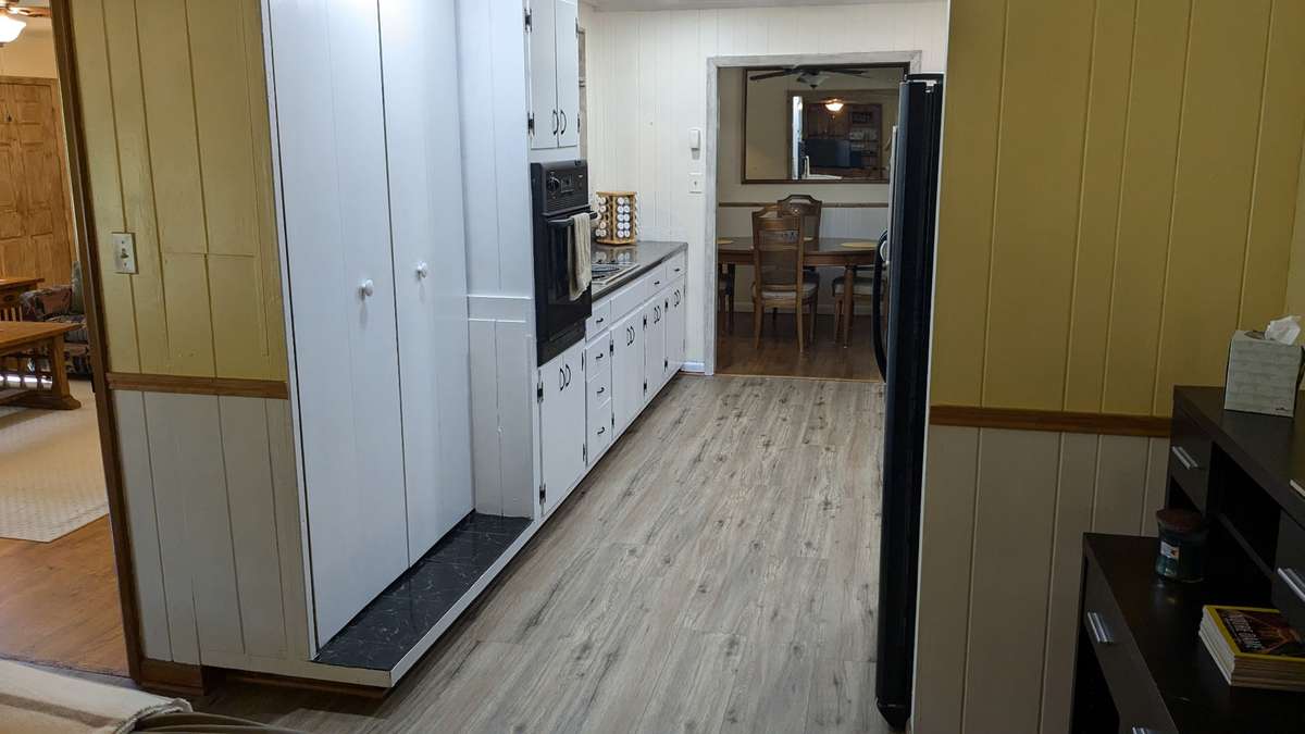 ...a wall oven, countertop stove, and pantry area, leading into...