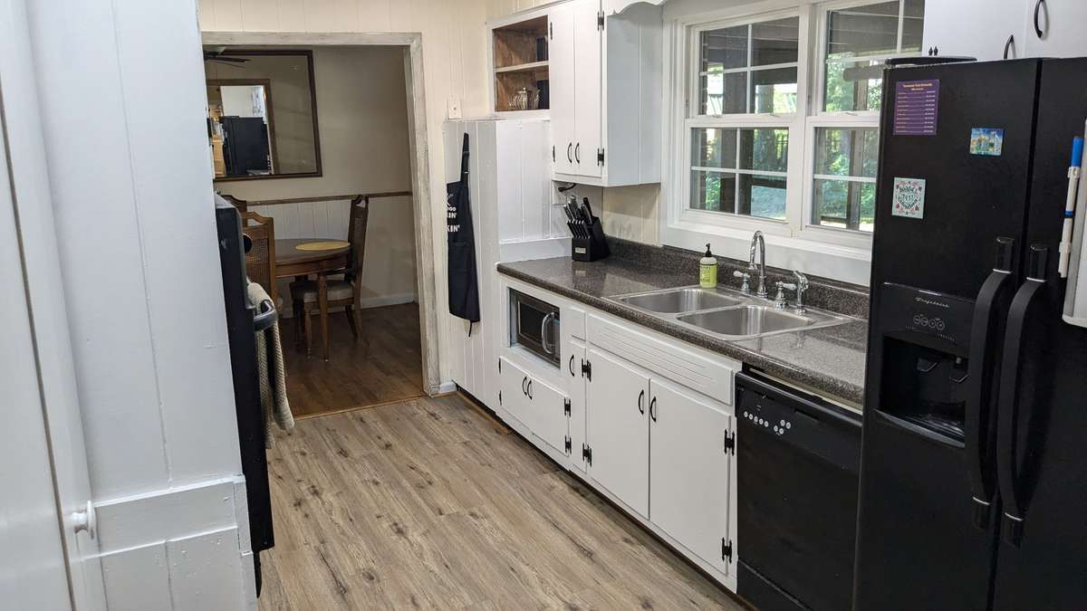 Also off the third living area is the bright kitchen with off-counter microwave space, windows overlooking the backyard...