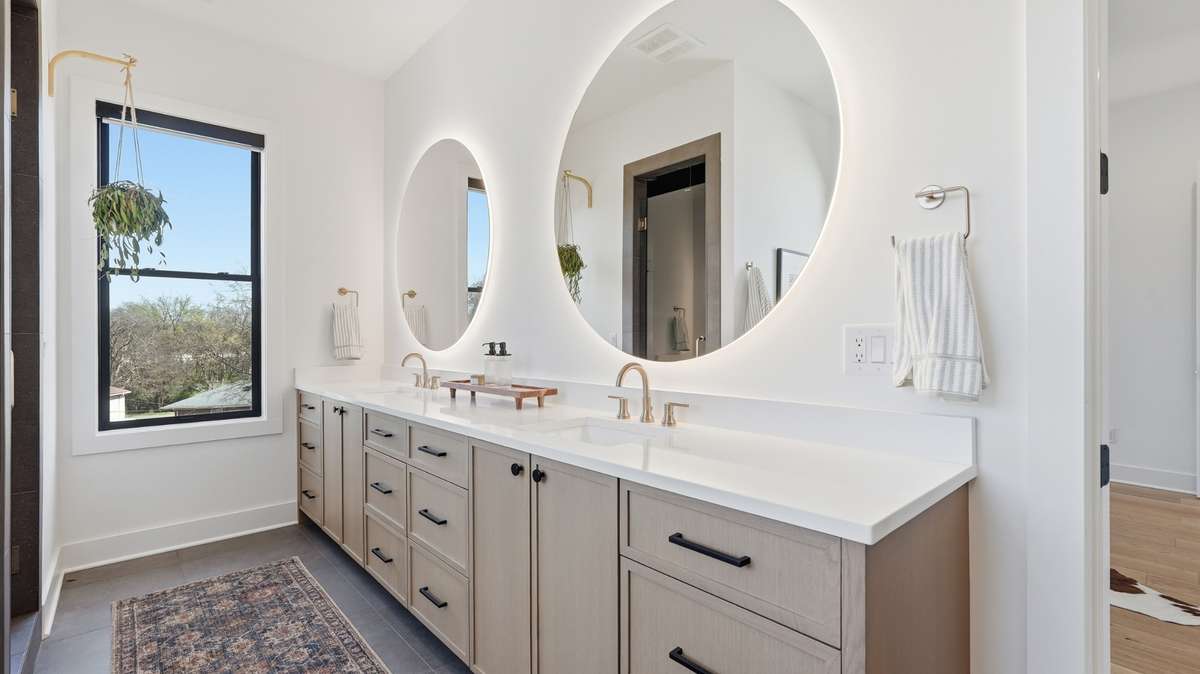 Primary bath with double vanities and a spacious double vanity and backlit mirrors