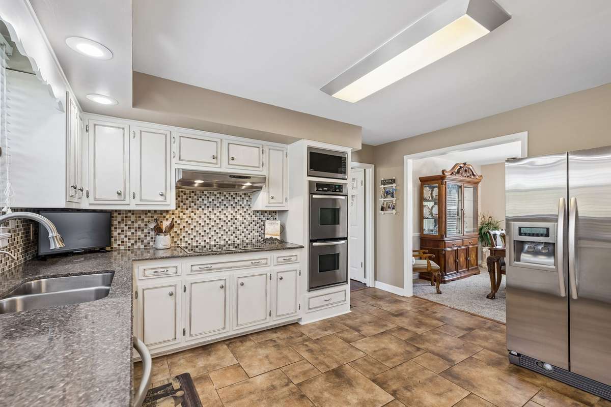 Tile flooring runs throughout the kitchen making cleanup easier while the built-in microwave and double oven stack keeps counter space clear for cooking.