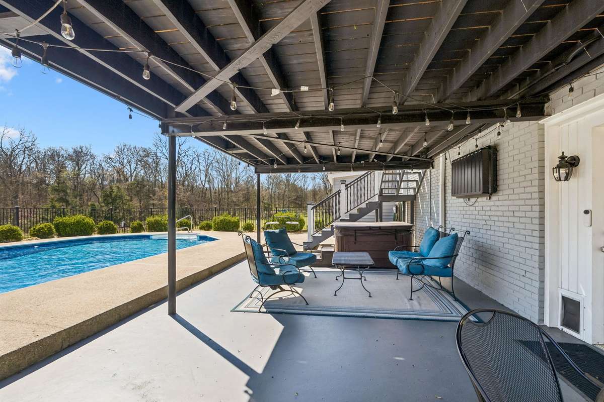 Retractable awning stretches across the deck to cut the sun while still keeping the view of the wooded acreage.
