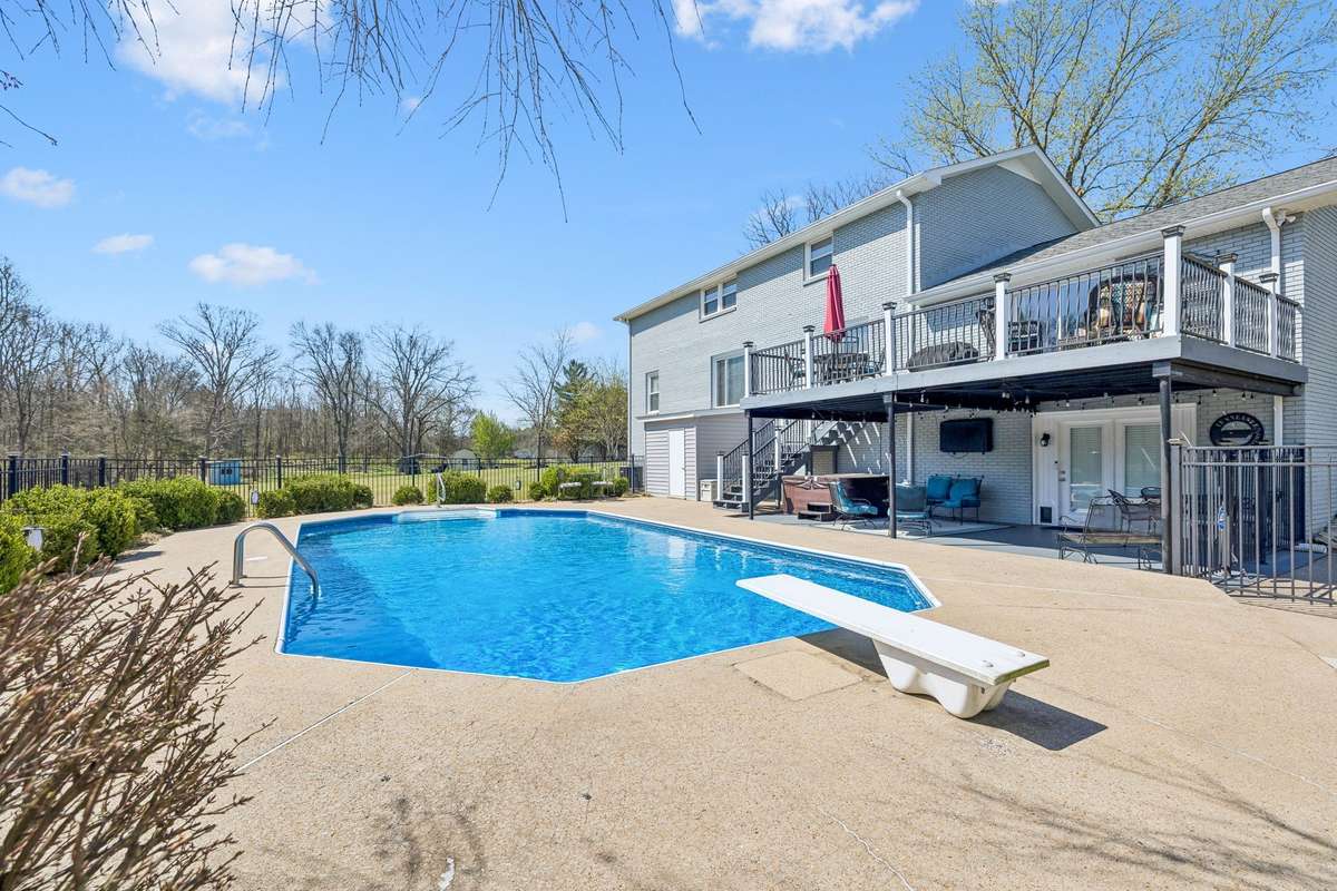 White diving board positioned over the deep end gives this inground pool a classic resort feel right in the backyard.