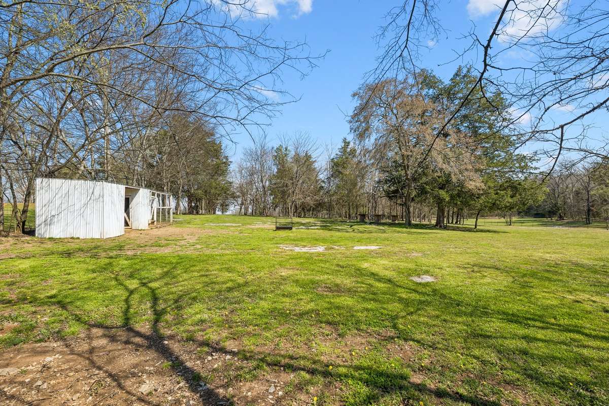 Outbuilding and workshop space sit on this level 17-acre lot with mature trees providing natural boundaries and privacy.