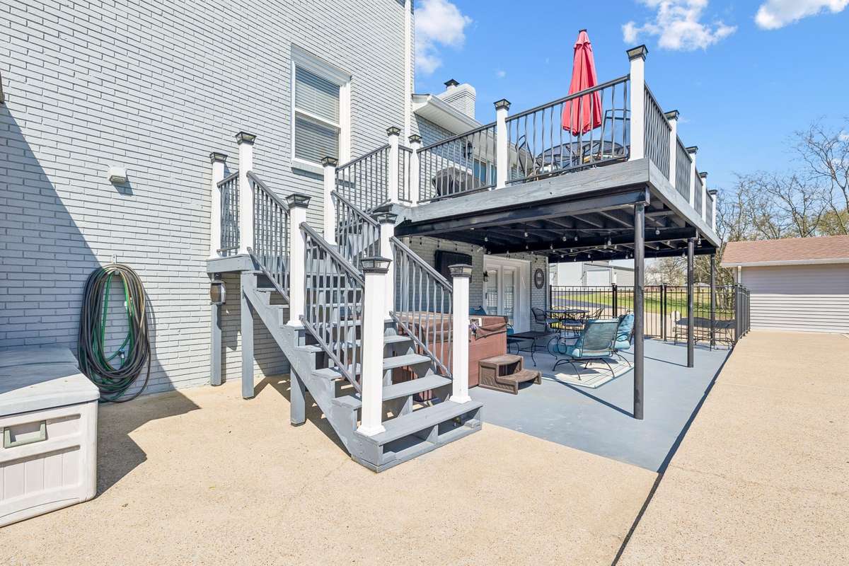 Two-level deck design with stairs leading to the upper level creates separate zones for lounging below and entertaining above.