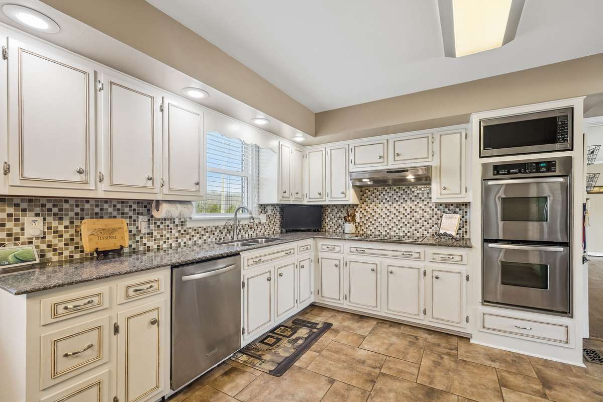 Built-in microwave and double oven stack creates a dedicated baking station with counter space nearby for cooling racks.