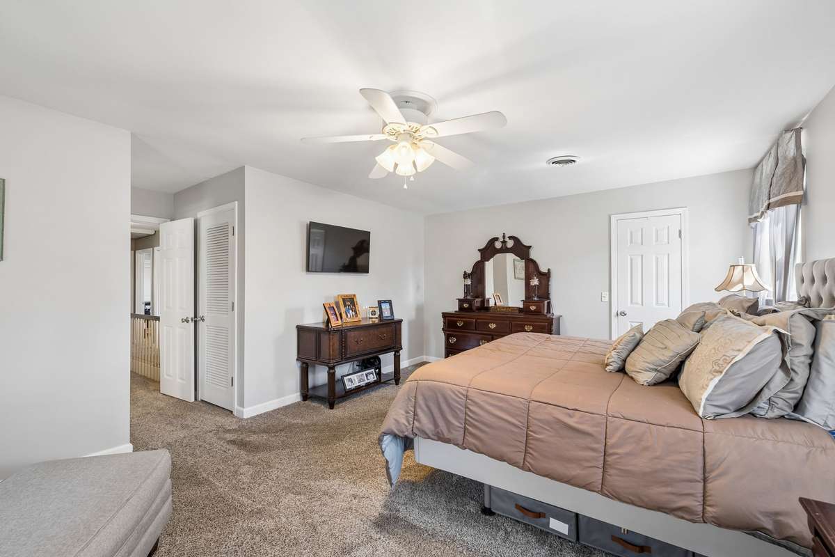 With bedding turned down and reading light on, this primary suite feels ready for someone to unwind after a long day.