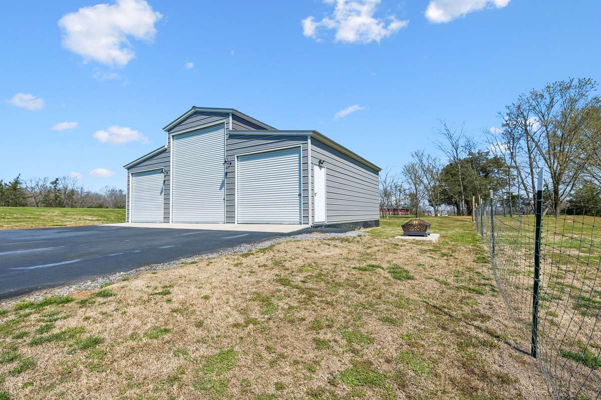 This spacious three-bay metal building provides serious workspace for projects, storage, and hobbies with multiple overhead doors for easy access.