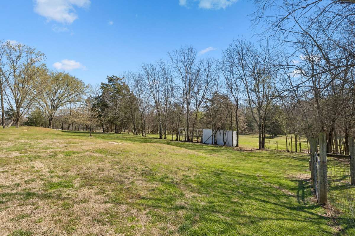 Open pasture with mature tree lines creates natural boundaries while the detached workshop sits ready for projects or extra storage needs.