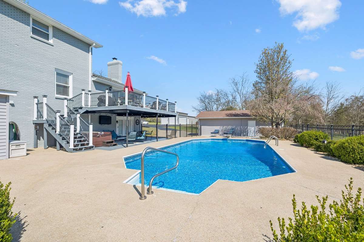 Stainless steel pool handrails and curved entry steps make getting in and out of this inground pool safe and easy.