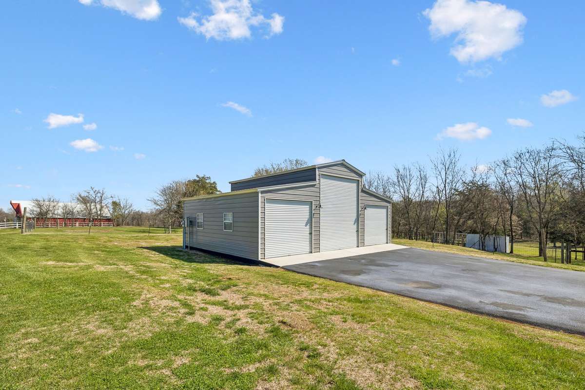 Three-bay metal shop with concrete pad provides protected workspace and storage for vehicles, tools, and equipment on this seventeen-acre Christiana property.