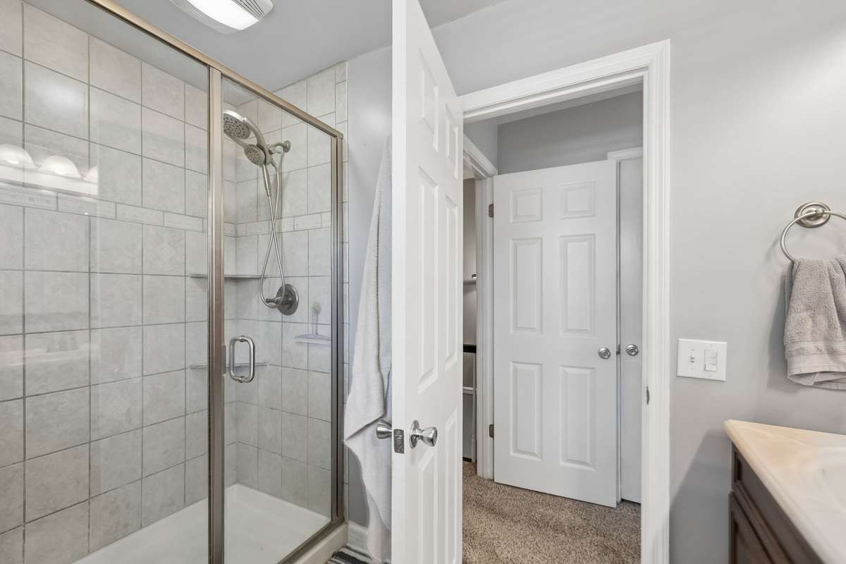 Glass shower door and tile surround give this upper level bathroom a clean, finished look that complements the home's updated feel.