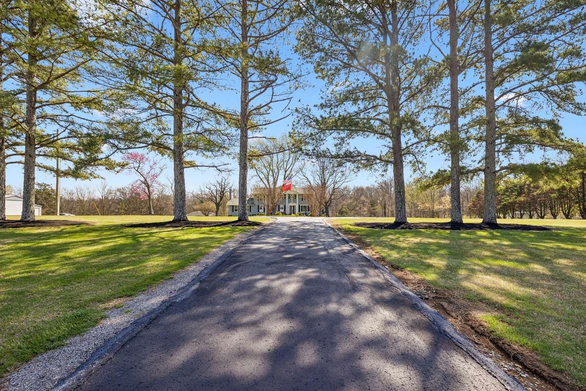 A tree-lined drive leads to this Christiana colonial with mature oaks casting shade across the expansive front lawn.