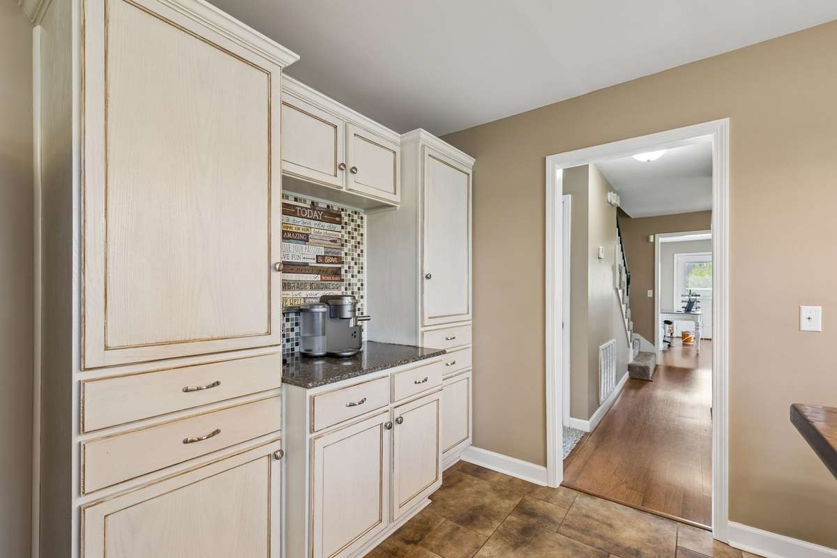 The butler's pantry offers dedicated counter space and cabinet storage that keeps kitchen prep organized while staying connected to the main cooking area.