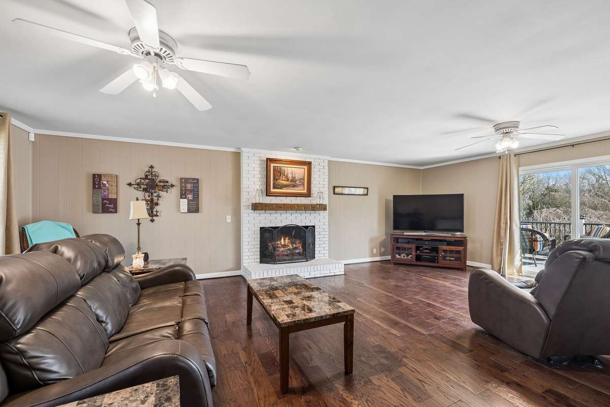 Dark hardwood floors run throughout this family room and extend toward the sliding doors that open to the covered outdoor space.