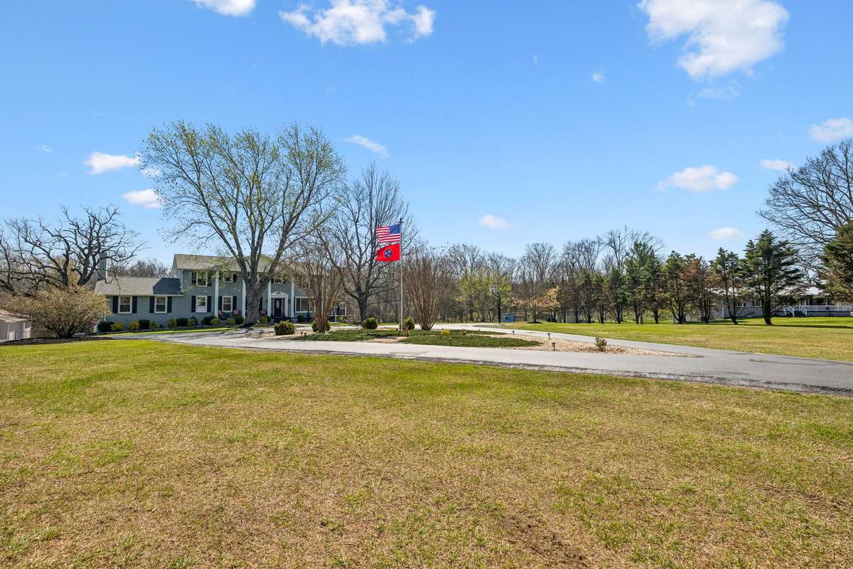 Expansive front yard with mature trees creates a private setting on this wooded 17-acre lot
