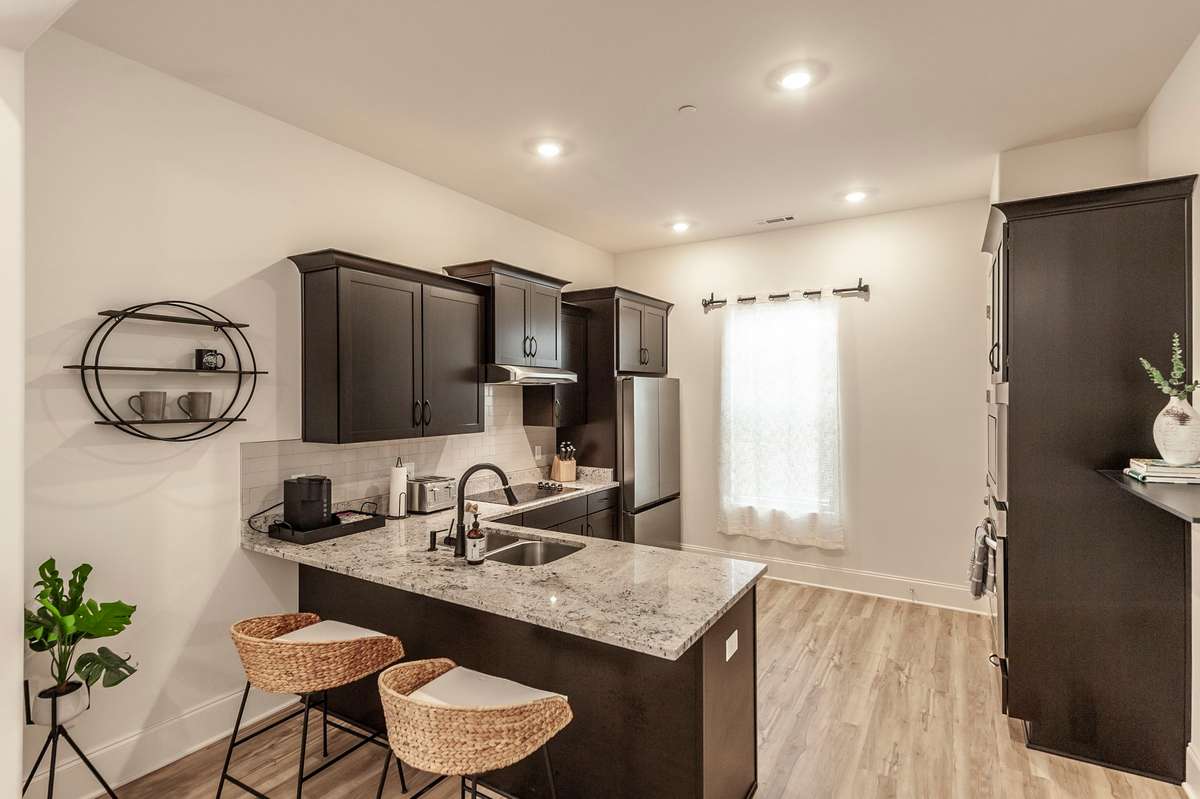 Granite countertops and ample cabinet and pantry space greet you in this well-appointed kitchen, complete with stainless appliances and a barstool area for gathering or quick meals!