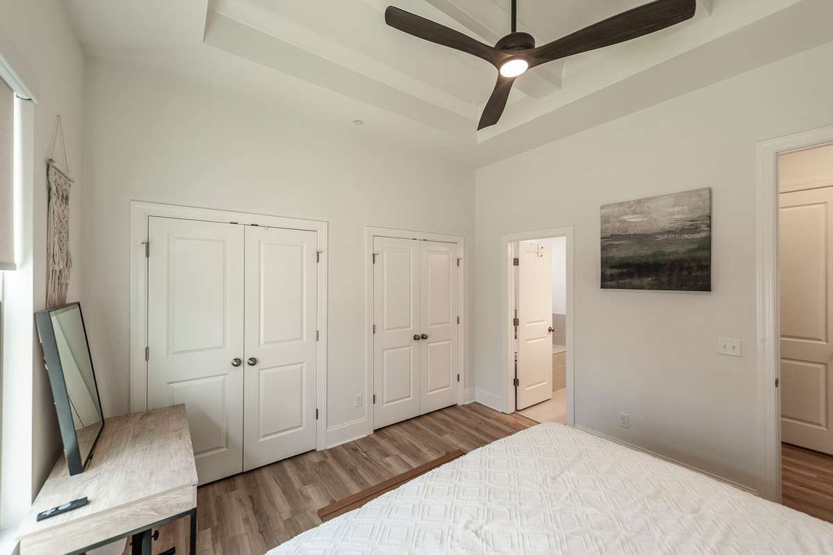 The primary bedroom features plenty of space, a coffered ceiling, and an upgraded ceiling fan!