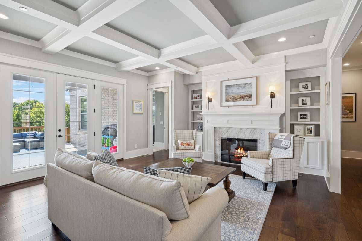 The formal living area is filled with natural light and anchored by a stunning marble fireplace, complemented by floor-to-ceiling built-ins that add both character and function.