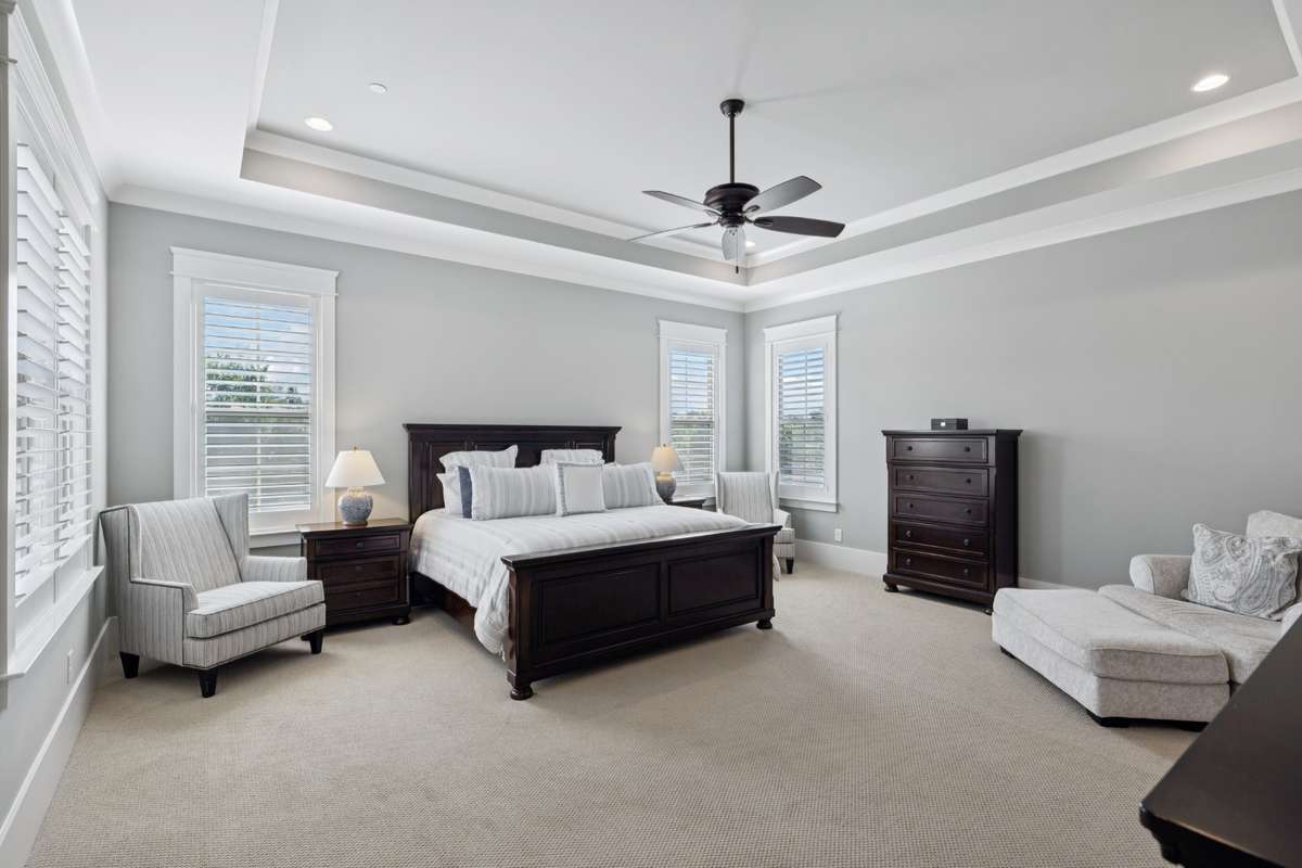 The main-level primary suite offers a peaceful escape with a tray ceiling and a spa-inspired bath complete with a soaking tub, dual vanities, and a beautifully finished walk-in shower.
