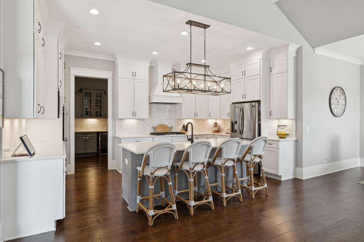 The kitchen serves as the heart of the home, featuring ceiling-height cabinetry, high-end appliances, and under-cabinet lighting.