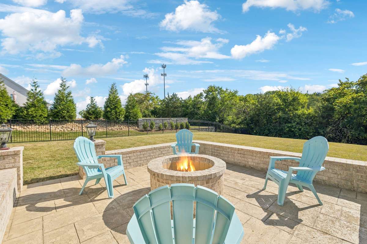 A lower patio with a built-in fire pit creates the perfect setting for relaxing evenings or gathering with friends.