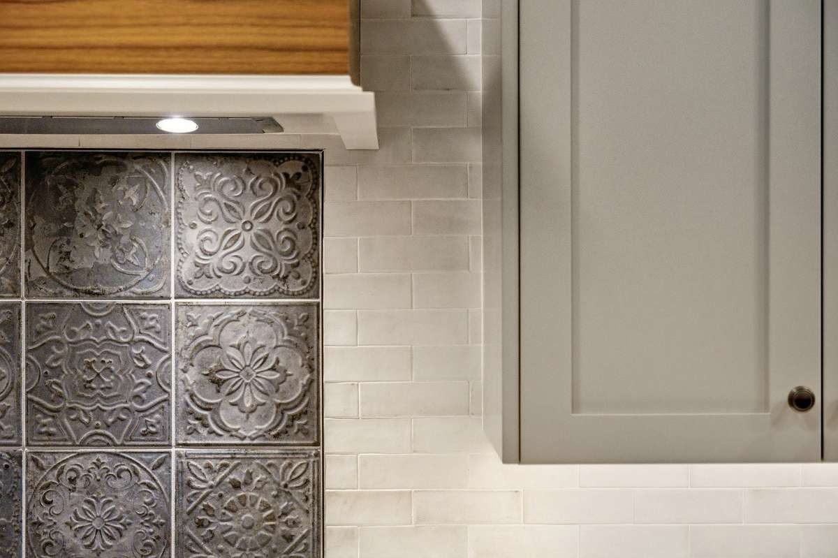 Darker accent backsplash tile behind the stove is attractive and functional for keeping a clean look even in the face of food prep.