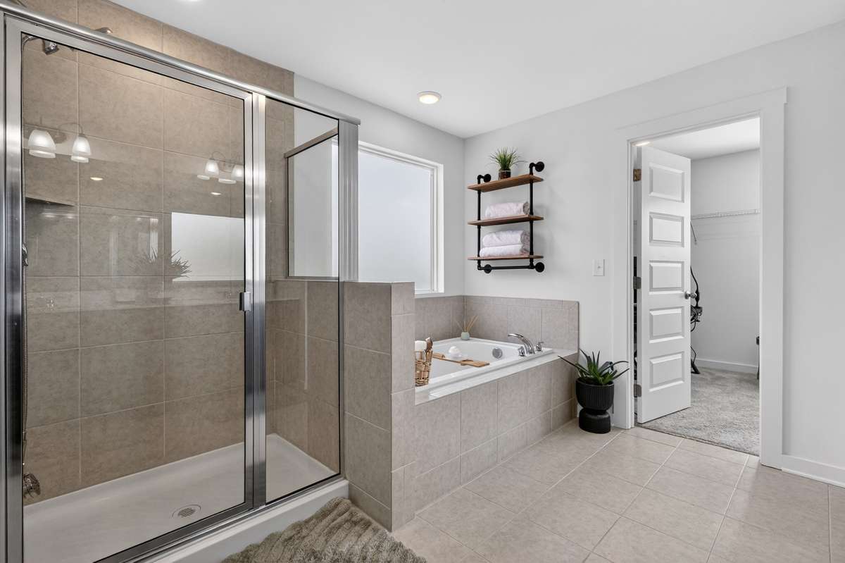 The primary bathroom is luxurious! Offering an enormous tiled shower and separate tub!! Double vanities and a mirror that extends the length of the wall!