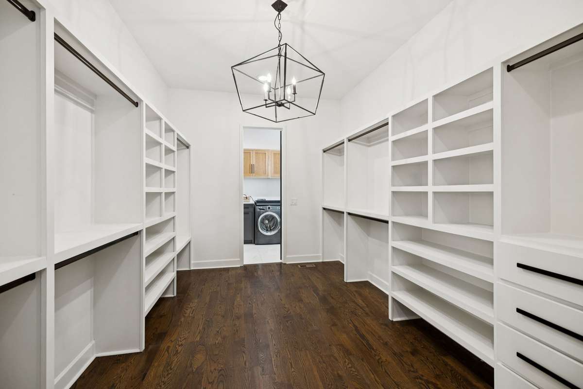 Oversized walk-in closet with custom shelving, hanging space, and direct access to laundry