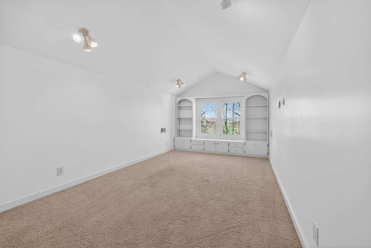 Privately situated bonus room above the garage with custom built-ins, providing a versatile space removed from the main living areas.