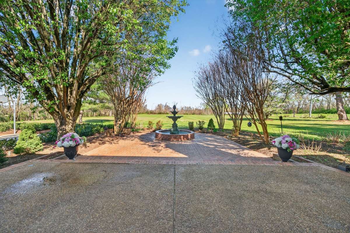 Peaceful patio setting surrounded by gardens, with a beautiful fountain as the centerpiece and private views stretching across the property.