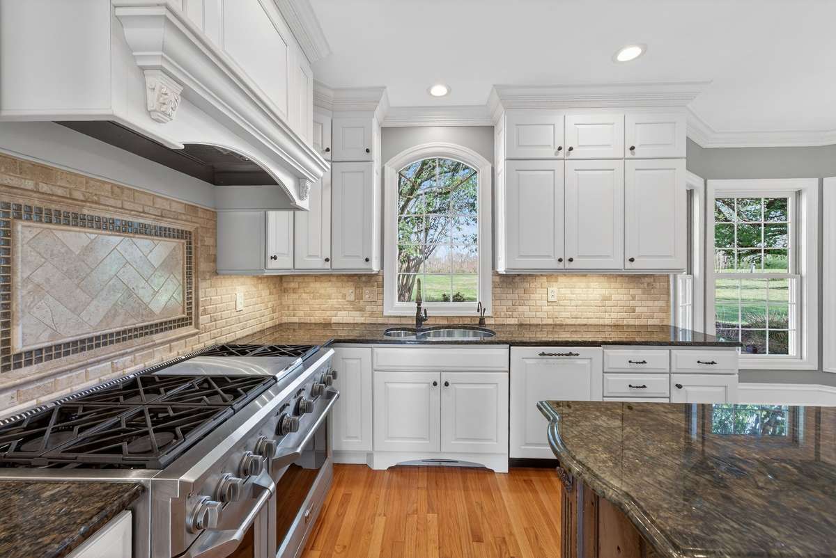 Beautifully appointed, the kitchen showcases high-end appliances and exquisite granite countertops sourced from Tanzania.