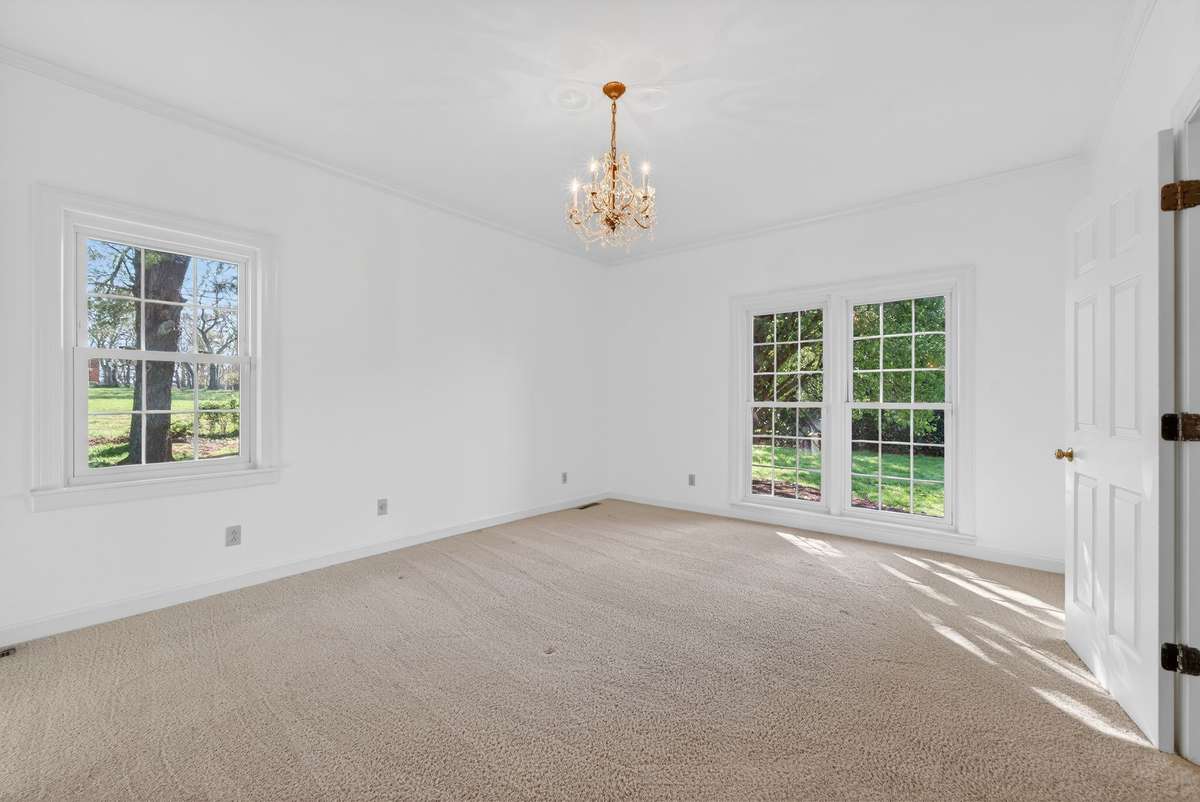 Bathed in natural light, this main-level suite offers versatility as a guest space or secondary primary retreat.