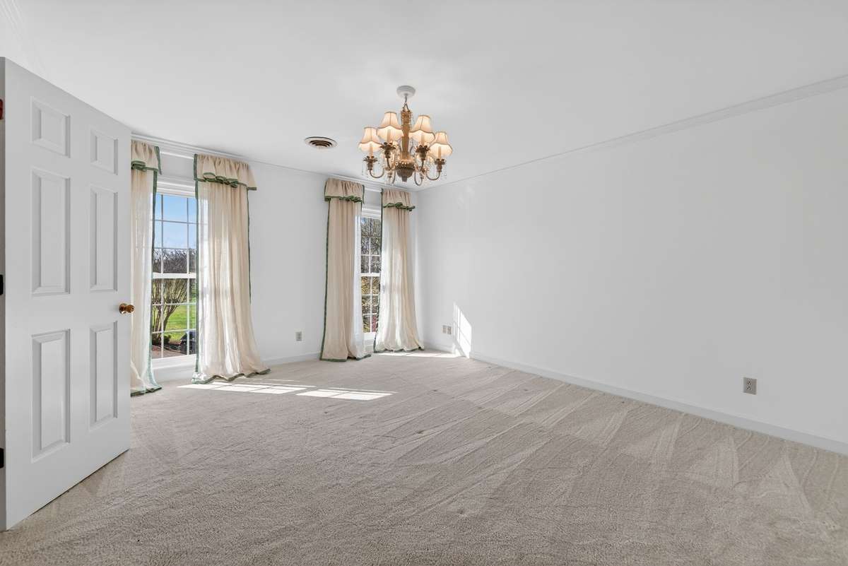 Light-filled bedroom, custom drapery and chandelier.