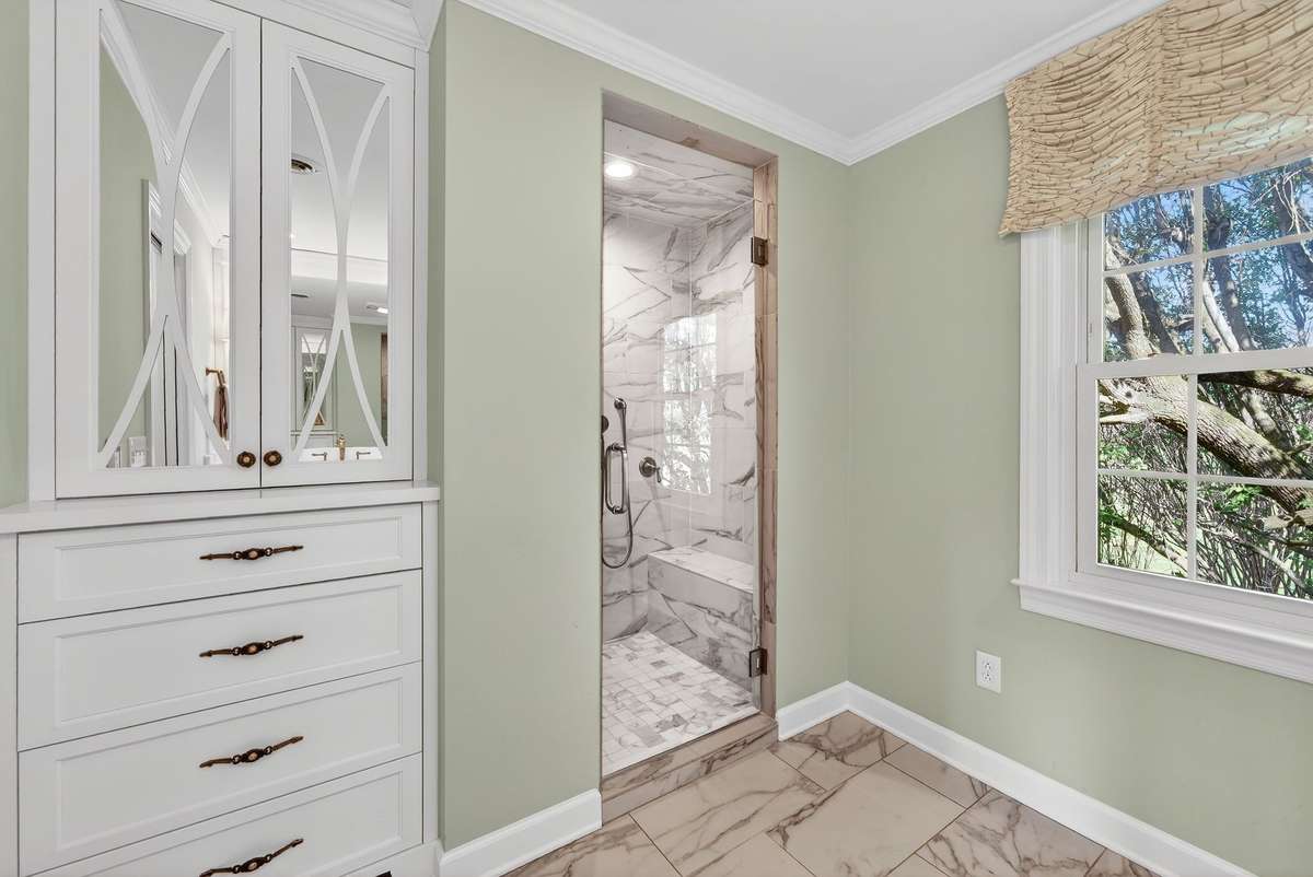 Ensuite bath offers marble countertops, heated floors, premium fixtures, and an expansive walk-in shower for a true spa-like experience.