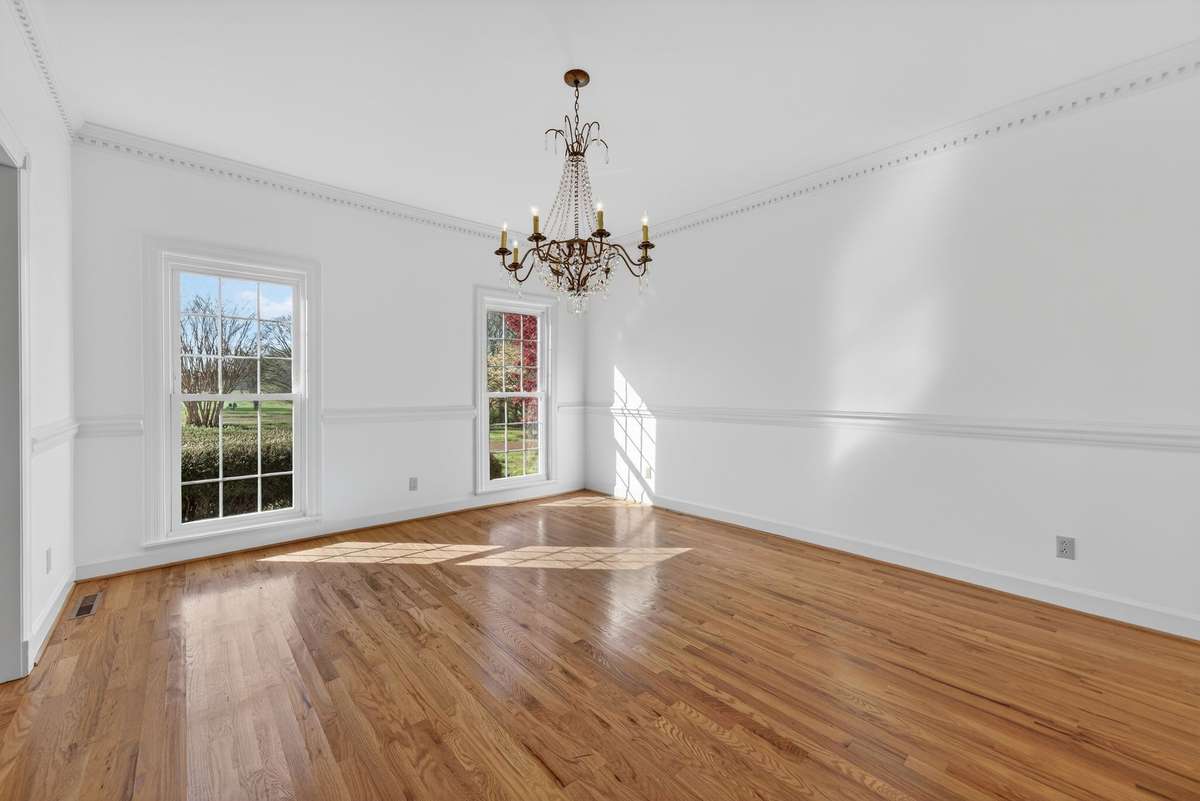 Timeless and refined, the formal dining room is anchored by a striking chandelier and designed to host a large dining table with ease.