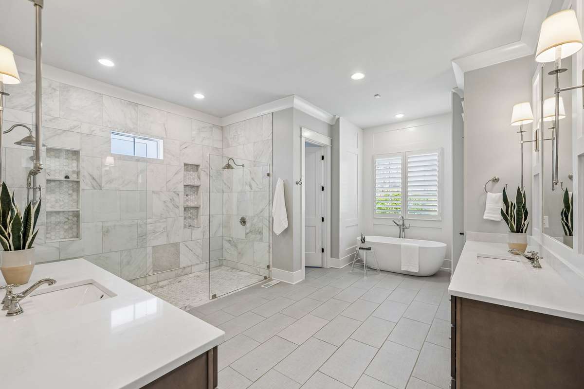 The spa-like bath offers dual vanities, a soaking tub, and an oversized walk-in shower, while dual walk-in closets and a private morning bar add an extra layer of luxury.