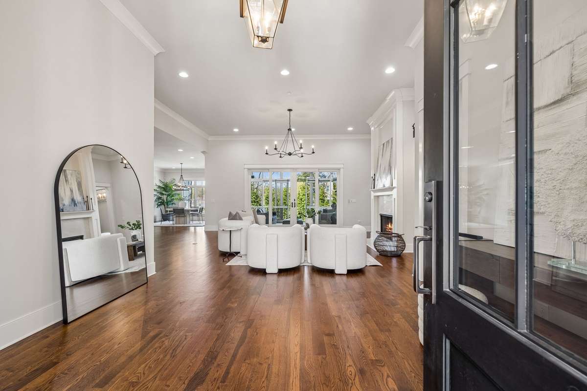 From the moment you arrive, the grand double iron French doors set the tone, opening into a light-filled foyer that immediately feels both refined and welcoming.