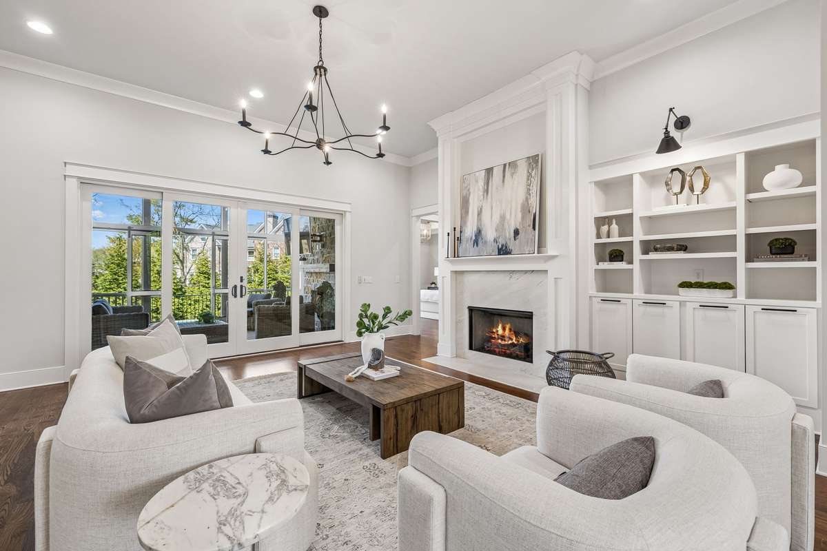 At the heart of the home, the living room invites you to gather and unwind. Custom built-ins frame a marble-surround gas fireplace, while a wet bar with beverage cooler and under-cabinet lighting makes entertaining feel effortless.