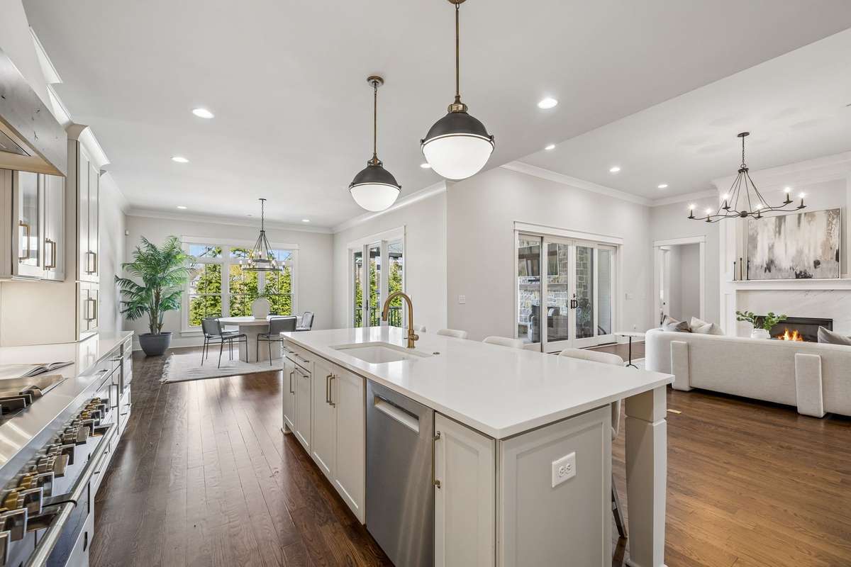 Quartz countertops, a generous 9-foot island, and two walk-in pantries offer ample space, while the breakfast nook and convenient grocery door from the garage make everyday living feel easy and thoughtful.