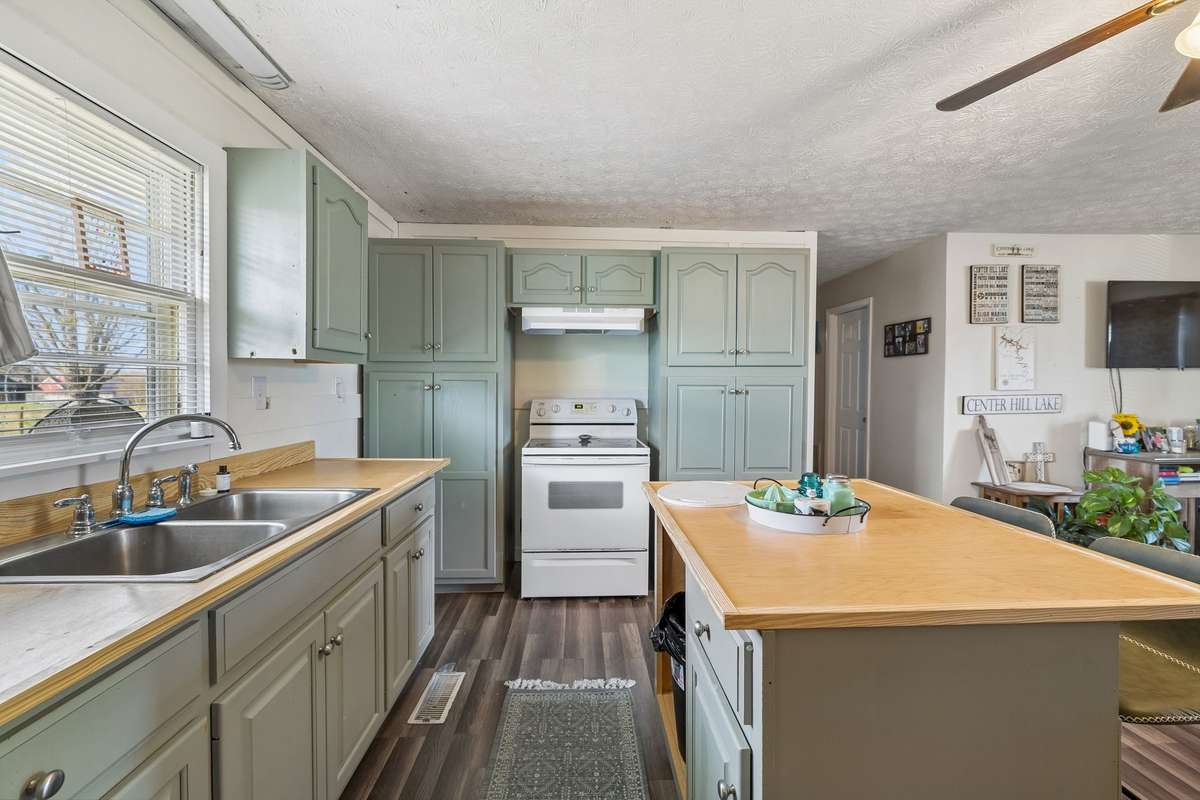 Bright and open kitchen features a stainless sink and easy to clean laminate flooring! 380 Holiday Haven Rd, Smithville, TN 37166