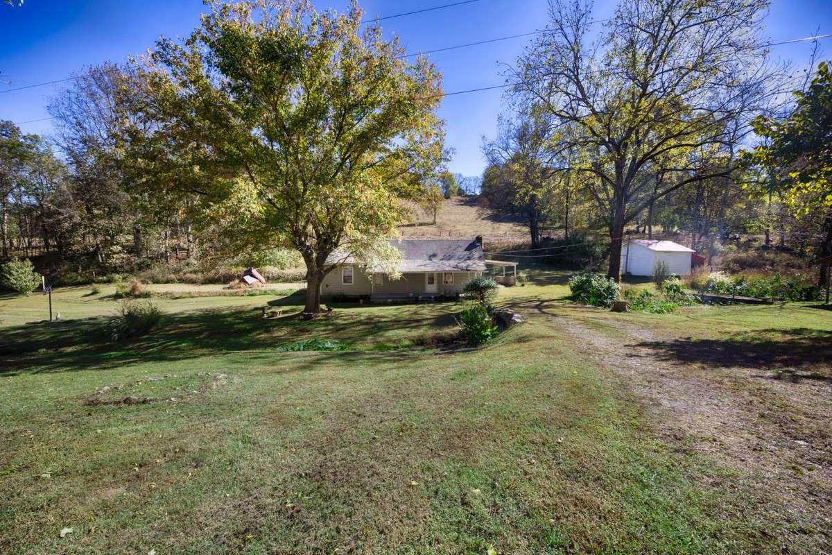 Front of house- covered front porch with home entry, Large yard with mature trees for shade