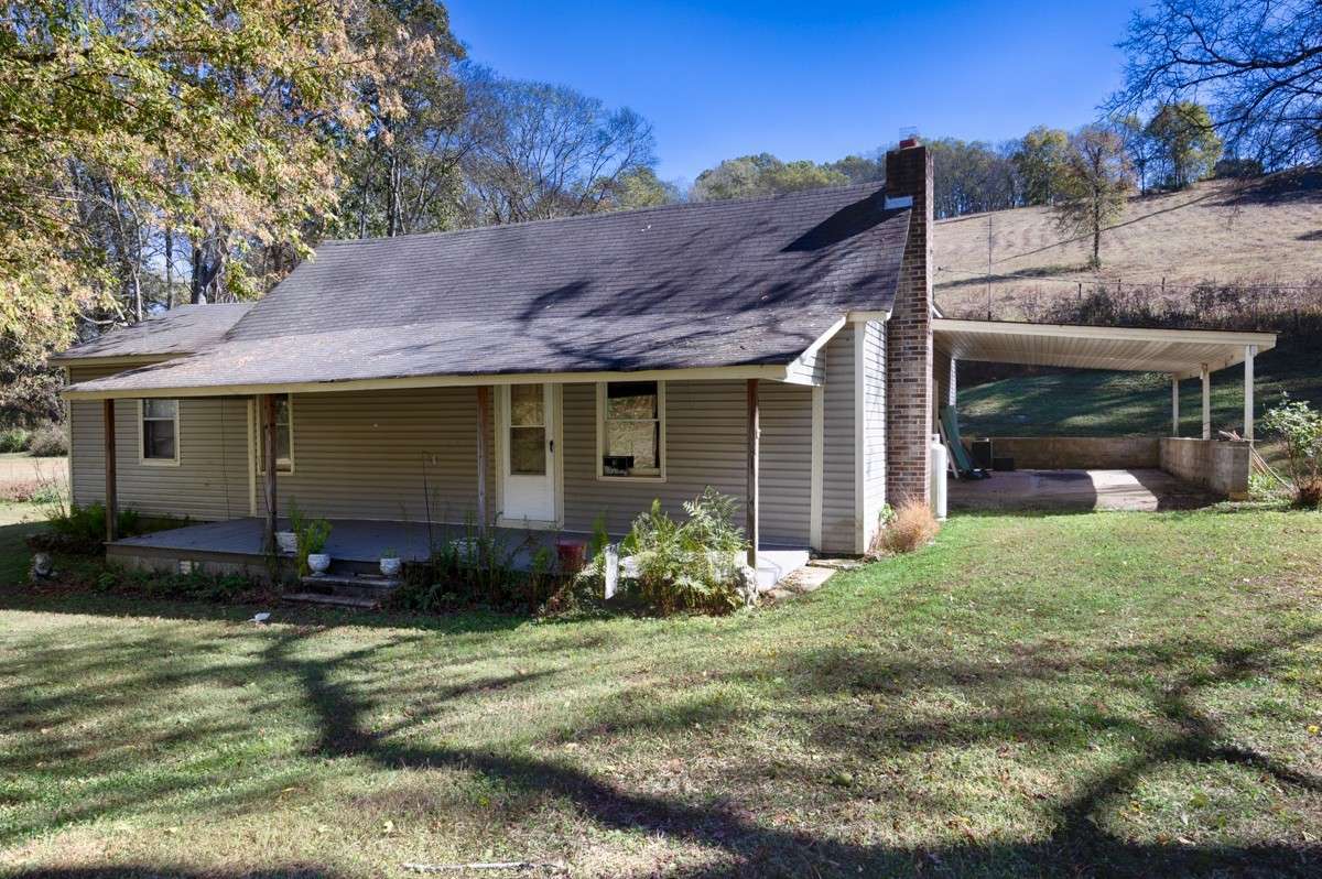 Front of house- covered front porch with home entry, Large yard with mature trees for shade