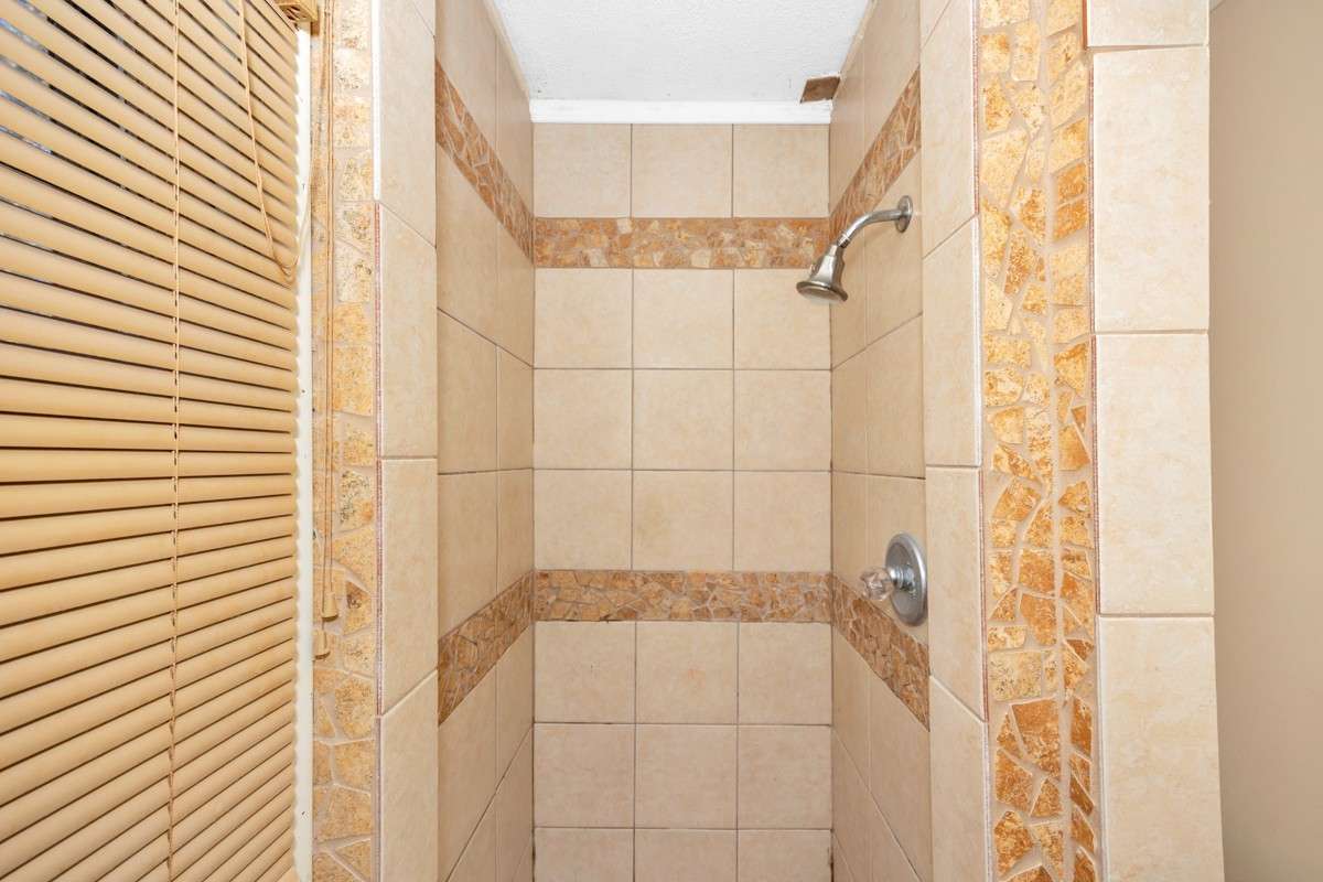 3/4 bathroom- tile flooring, tile shower, crown molding