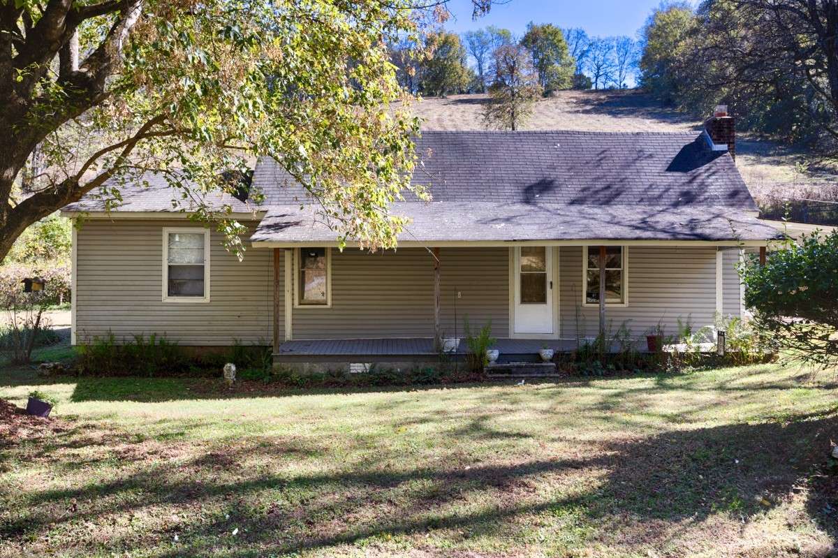 Front of house- covered front porch with home entry, Large yard with mature trees for shade