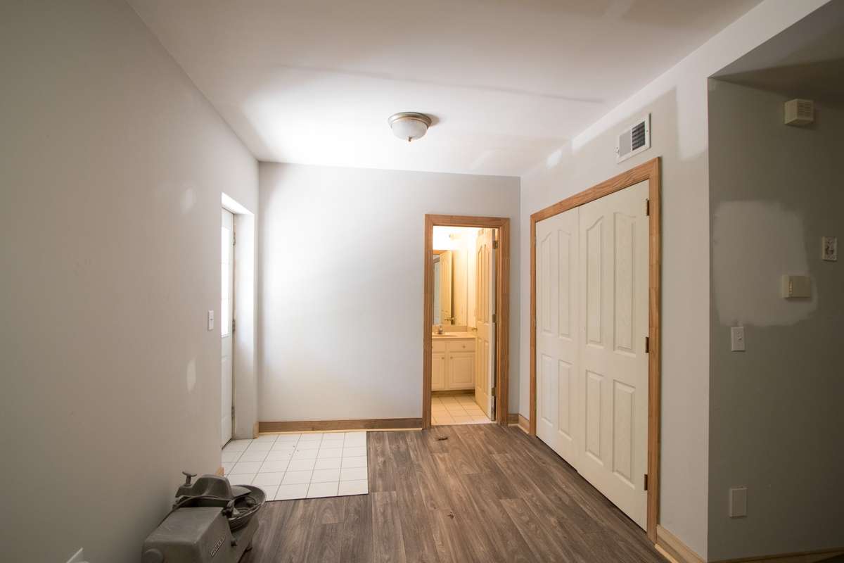 Bedroom and bath area of basement apartment. Door to left goes out to concrete patio and to driveway.